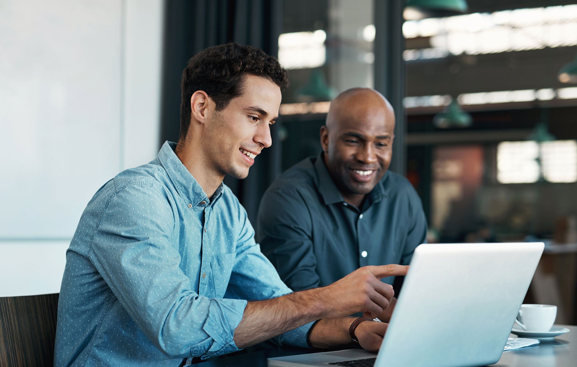 Two men looking at a laptop
