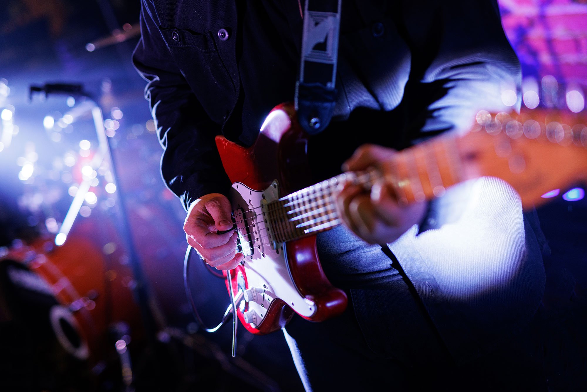Man on stage playing a guitar 