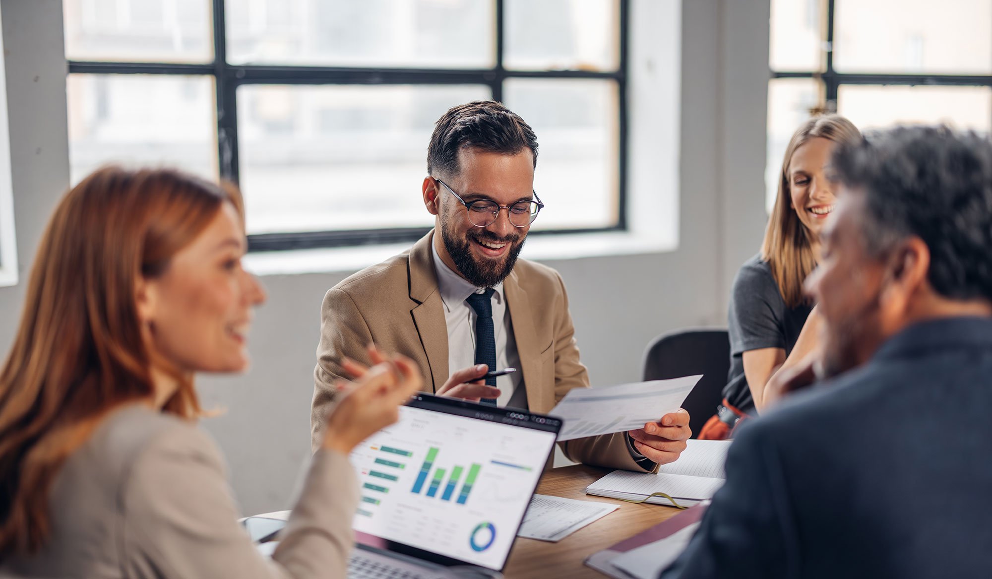 a group of coworkers gathered around a table discussing strategy