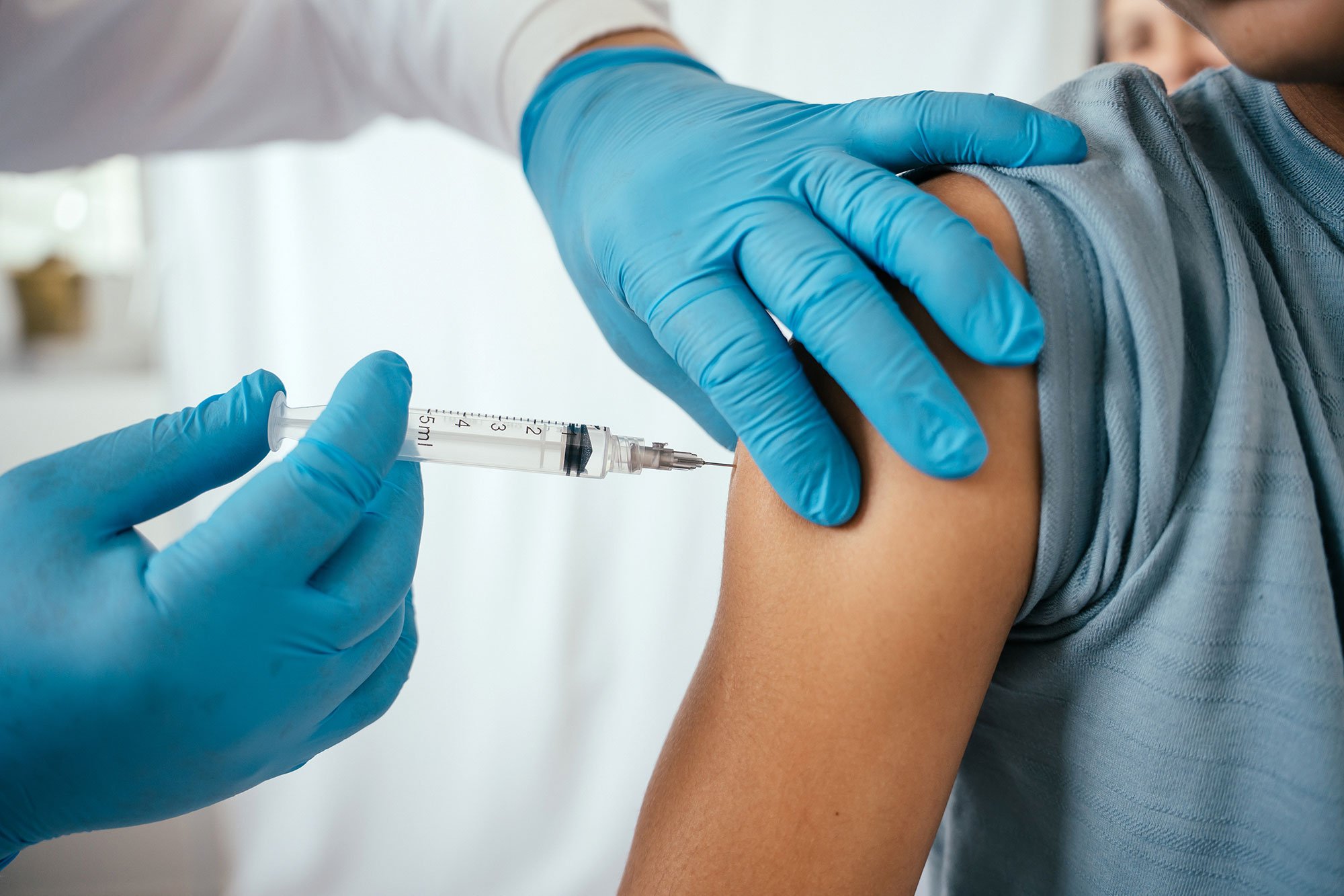 Nurse giving a vaccine to a patient in their upper arm
