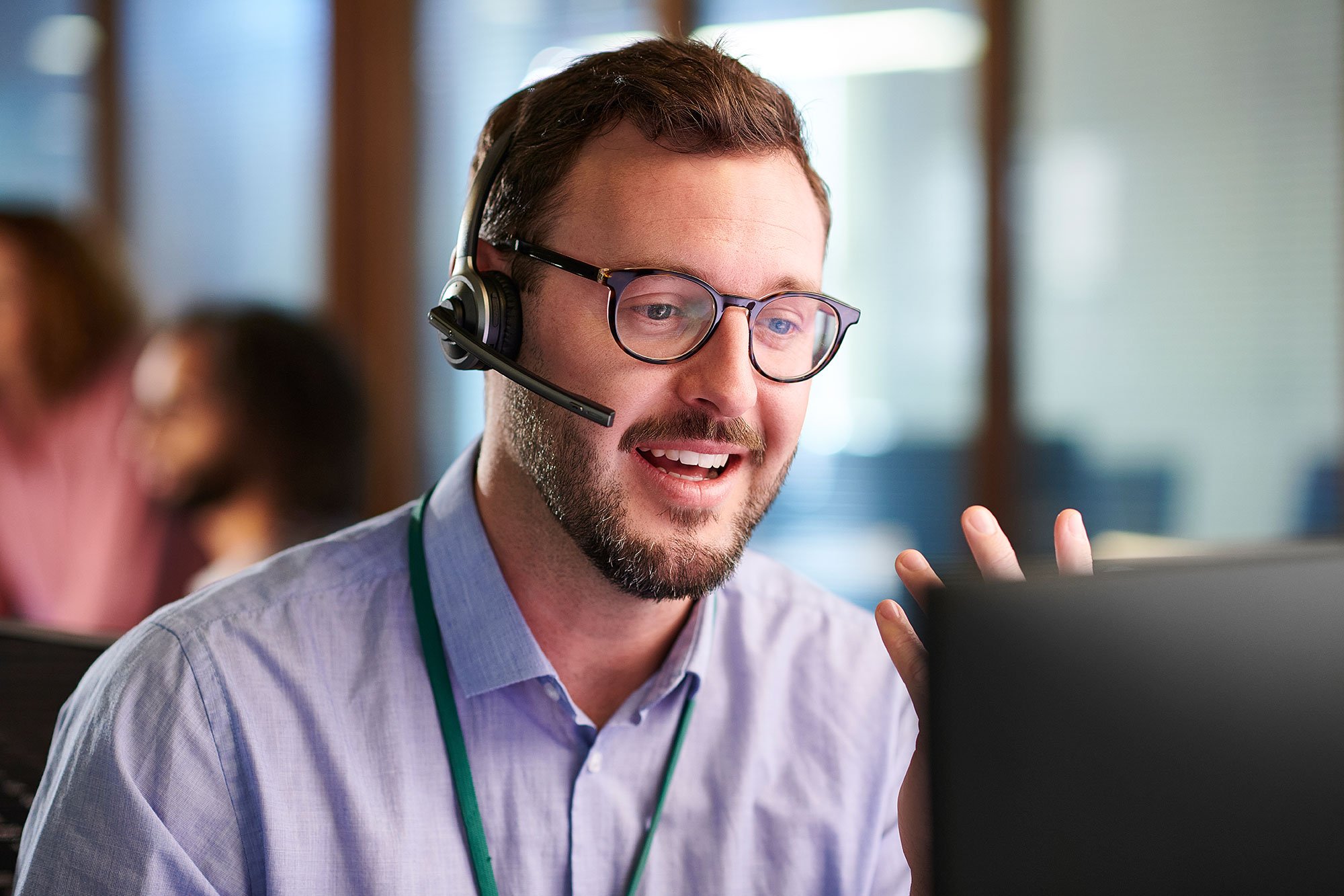 Man with glasses using a headset to talk with a customer